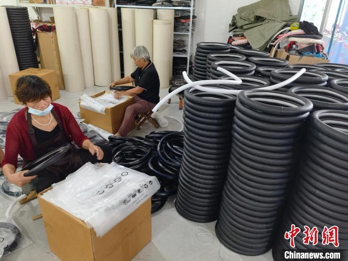 圖為村民在汽車飾品企業(yè)生產(chǎn)車間中工作?！巫雍?攝