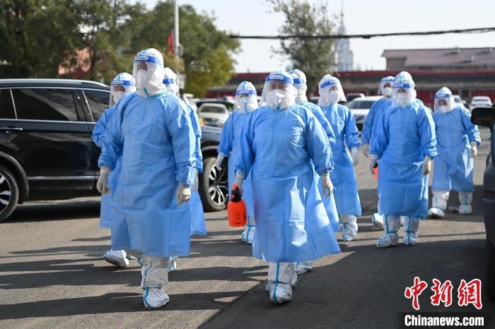 圖為醫(yī)務(wù)人員在封閉小區(qū)做防控工作。　劉文華 攝