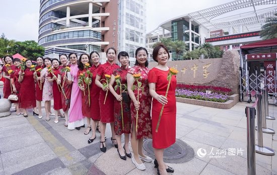 6月7日一早，廈門雙十中學考生家長們身穿旗袍，手拿向日葵在考場外為孩子加油打氣，寓意“旗開得勝，一舉奪魁”。人民網(wǎng)記者 陳博攝