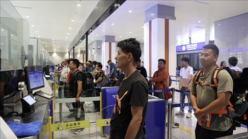6月13日，乘坐中老鐵路國際旅客列車的旅客在磨憨邊檢大廳排隊(duì)候檢。李揚(yáng) 攝