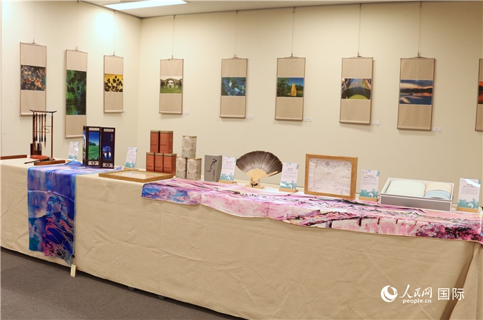 現(xiàn)場展出的馮學(xué)敏攝影作品與湖州市特色工藝品。（人民網(wǎng) 許可攝）