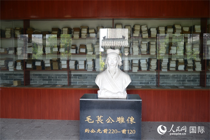 河間詩經齋毛萇雕像。雕像后書櫥中陳列的是歷代各版本《詩經》及譯本。 人民網 趙昭攝