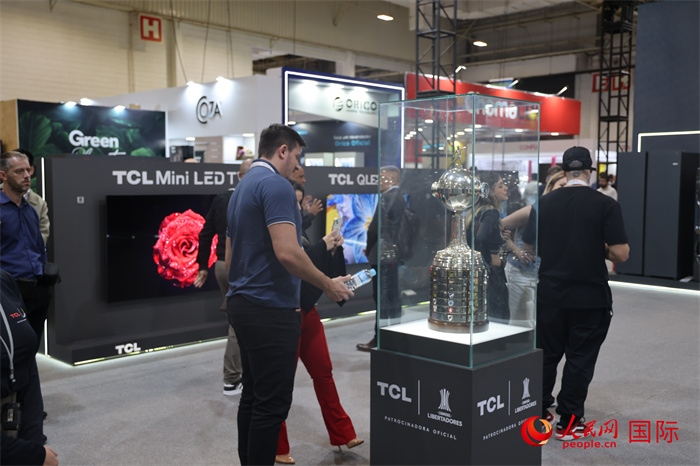參觀者在TCL展臺(tái)前觀看南美解放者杯獎(jiǎng)杯，據(jù)介紹，TCL是南美解放者杯（2023—2026賽季）全球官方合作伙伴。（人民網(wǎng)記者 時(shí)元皓攝）