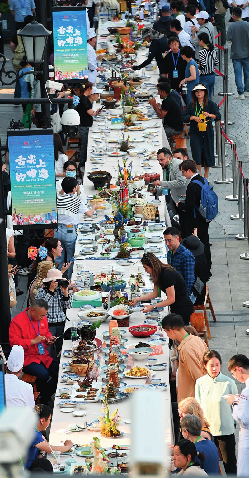 市民和游客在寧波舉辦的第三屆中國—中東歐國家博覽會(huì)暨國際消費(fèi)品博覽會(huì)上品嘗融合中國和中東歐美食的長桌宴（2023年5月15日攝）。黃宗治攝/本刊