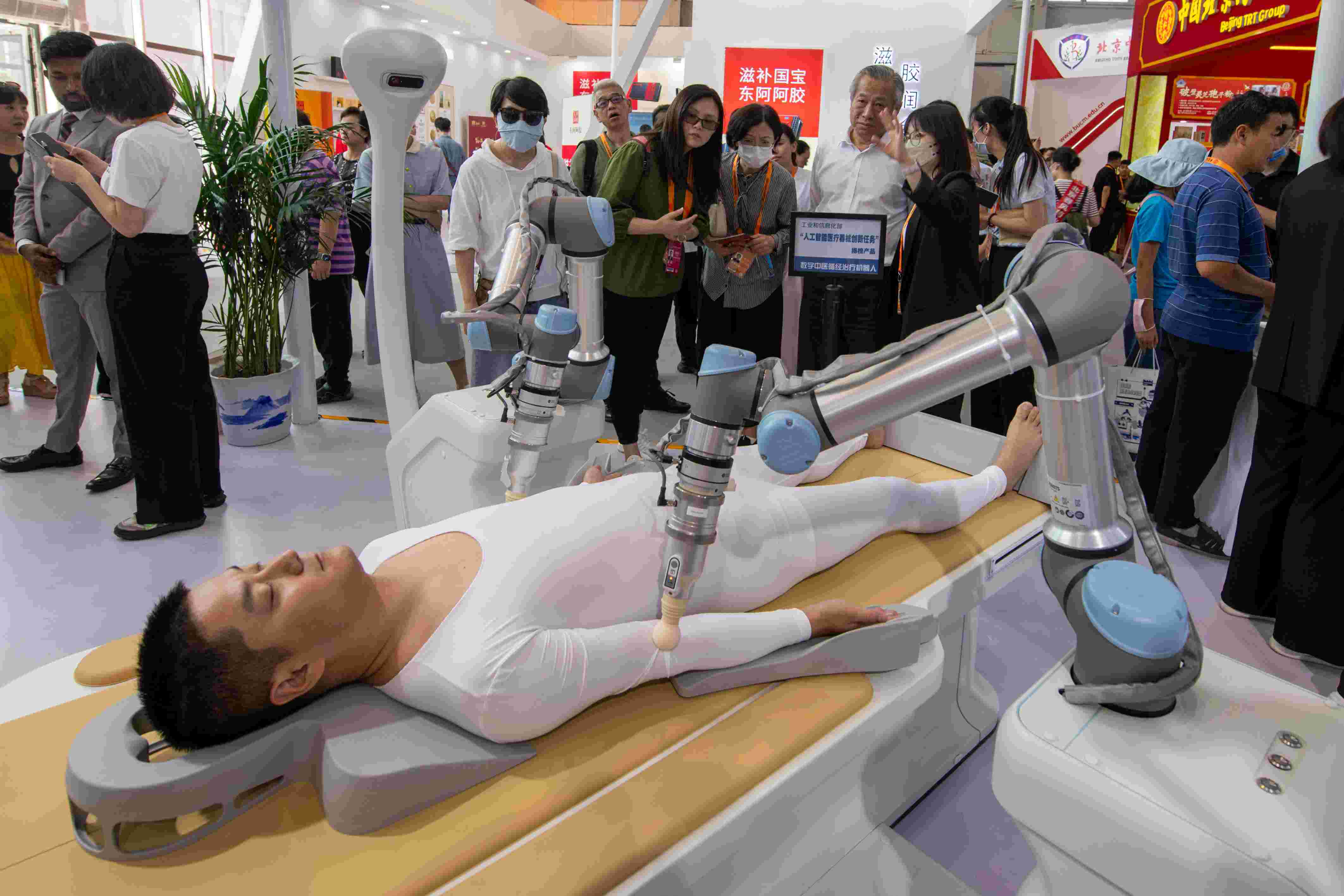 在位于首鋼園的健康衛(wèi)生服務(wù)展區(qū)，觀眾正在參觀數(shù)字中醫(yī)循經(jīng)治療機(jī)器人。人民網(wǎng)記者 翁奇羽攝
