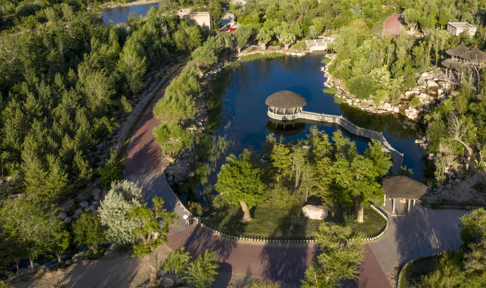 坐落在寧夏銀川市賀蘭山腳下的賀蘭山運(yùn)動休閑公園（2021年5月27日攝，無人機(jī)照片）。這里曾是一片砂石采礦塌陷區(qū)，當(dāng)?shù)赝ㄟ^植被景觀再造、水系建設(shè)、現(xiàn)代管網(wǎng)鋪建等手段，重新利用廢石、廢坑及各類廢棄建筑材料，把這里變成一座免費(fèi)開放的主題公園。新華社記者 馮開華 攝