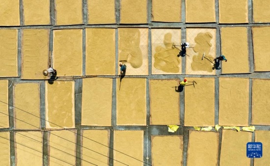 9月16日，在湖南省懷化市通道侗族自治縣萬(wàn)佛山鎮(zhèn)溪上村，村民在晾曬稻谷（無(wú)人機(jī)照片）。