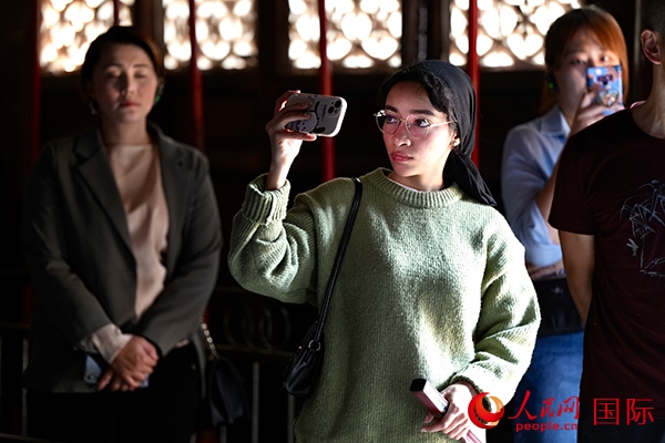 選手顏青（蘇丹）用手機(jī)記錄所見所感。人民網(wǎng) 盧鵬宇攝