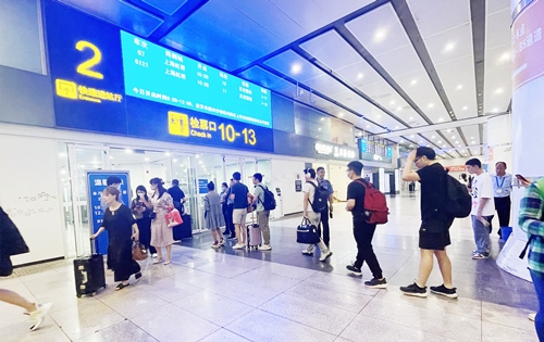 在快速進站廳前排隊等待檢票的旅客。人民網(wǎng)記者 喬雪峰攝