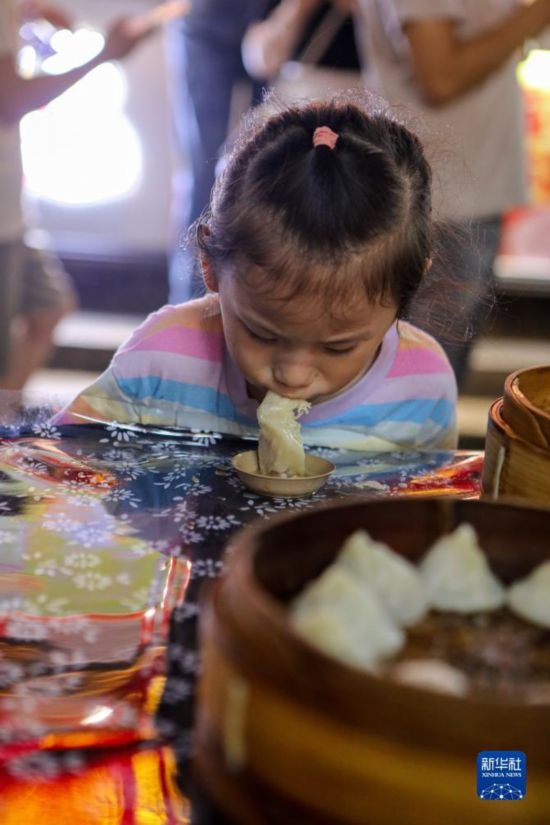 9月27日，小朋友在南翔小籠長街宴上品嘗南翔小籠。