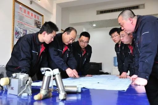 △李志強(qiáng)（左二）與班組成員在研究工作。