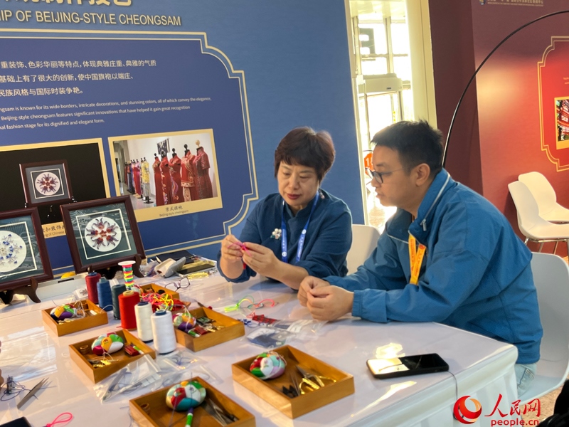 記者在新聞中心非遺傳承人展區(qū)進行體驗。人民網(wǎng)記者 杜燕飛攝