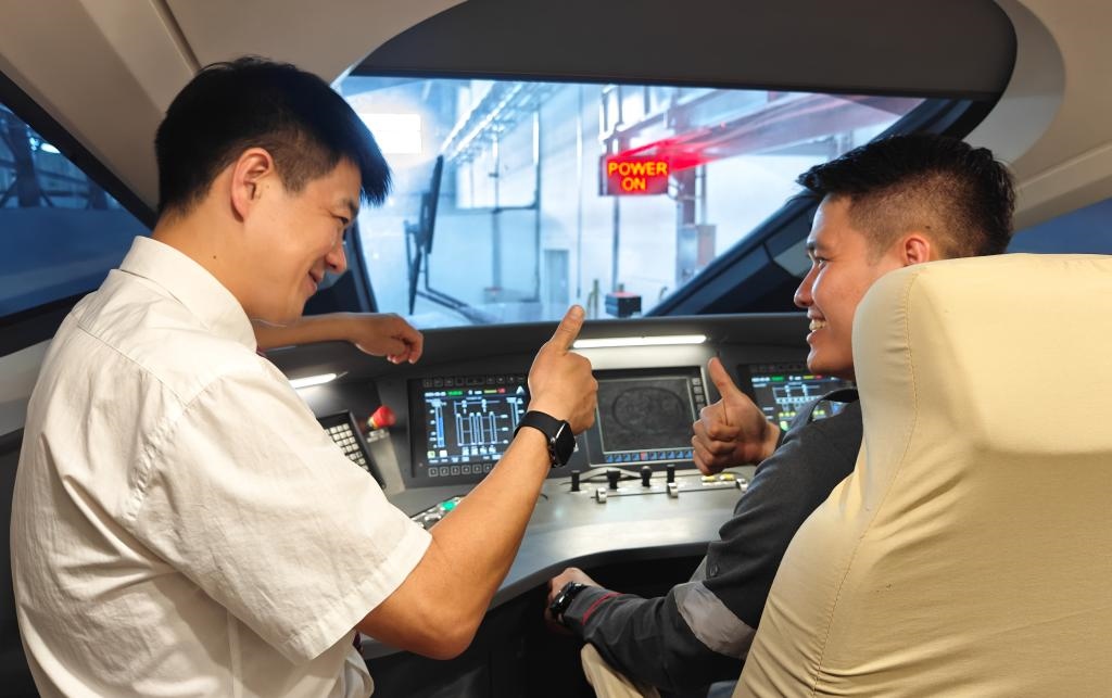 8月25日，在印度尼西亞萬(wàn)隆的雅萬(wàn)高鐵德卡魯爾動(dòng)車(chē)所內(nèi)，中國(guó)師傅穆振（左）在向印尼火車(chē)司機(jī)塞蒂亞萬(wàn)講解動(dòng)車(chē)組出庫(kù)前的上電作業(yè)。