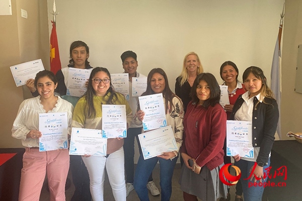 社區(qū)工作專家莫伊拉（后排右二）向“中文工坊”第二期培訓(xùn)班部分結(jié)業(yè)學(xué)員頒發(fā)由薩爾塔省教育部簽發(fā)的結(jié)業(yè)證書。人民網(wǎng)記者 吳思萱攝