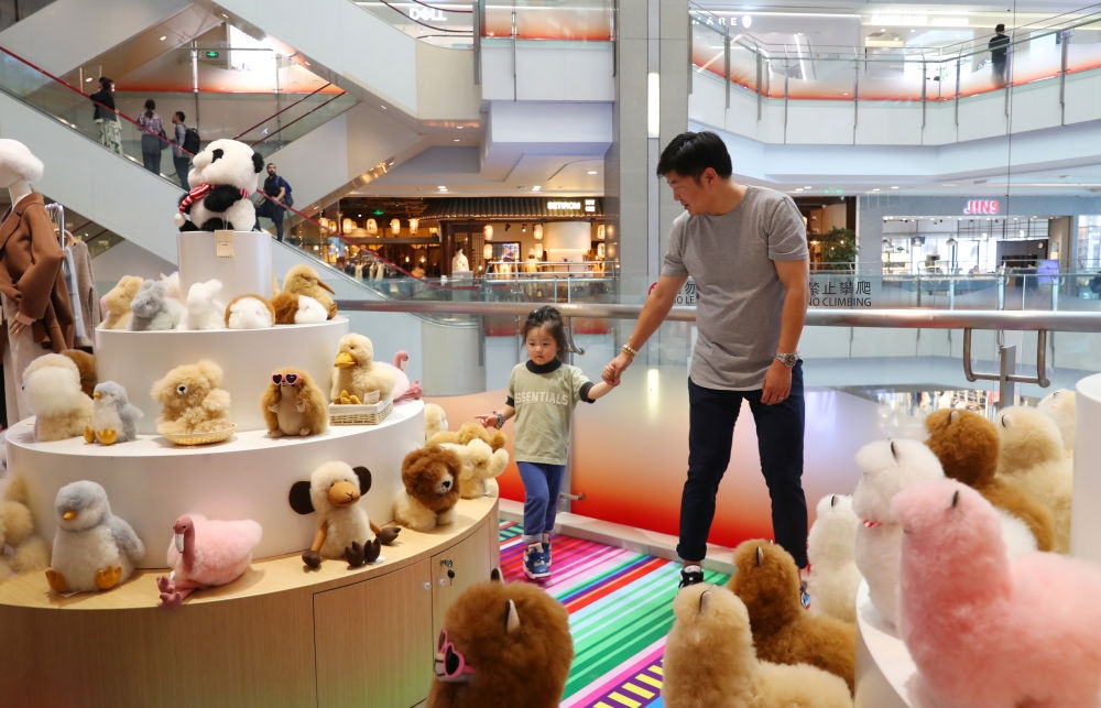 2023年11月2日，顧客在溫暖駝品牌專柜內(nèi)選購(gòu)。連續(xù)六年參加進(jìn)博會(huì)的秘魯羊駝制品品牌溫暖駝在上海市中心商場(chǎng)開(kāi)設(shè)了專柜。新華社記者 方喆 攝