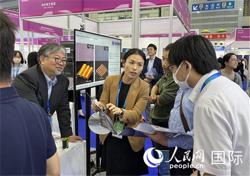 工作人員向參觀者介紹超級噴墨技術(shù)。（人民網(wǎng)記者 陳思攝）