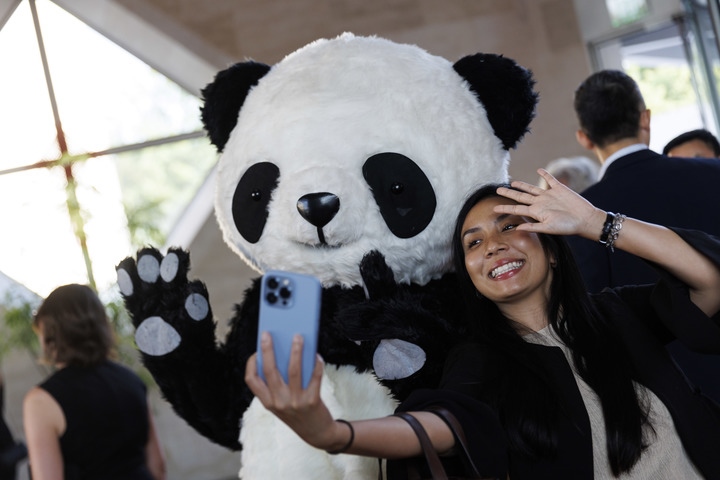 2022年8月24日，在美國華盛頓中國駐美國大使館，來賓與大熊貓玩偶合影。