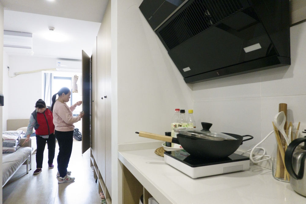 住戶在閔行區(qū)新時代城市建設者管理者之家收拾房間。