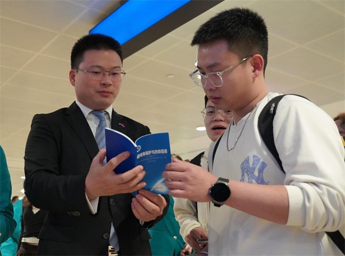 工作人員（左一）在發(fā)放《中國領(lǐng)事保護(hù)與協(xié)助指南》。 中國駐迪拜總領(lǐng)事館供圖