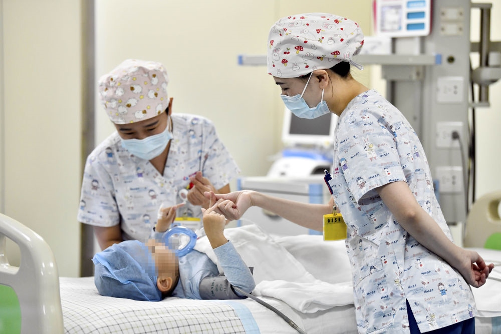 在山東省棗莊市婦幼保健院兒童ICU病房，醫(yī)護(hù)人員為完成靶向治療藥物諾西那生鈉的4歲脊髓性肌萎縮癥患兒加油鼓勁（2022年1月1日攝）。諾西那生鈉注射液是我國首個(gè)獲批治療脊髓性肌萎縮癥的進(jìn)口藥物，2019年進(jìn)入中國市場時(shí)，每針價(jià)格近70萬元。在2021年國家醫(yī)保目錄藥品談判中，以3.3萬元每針的價(jià)格進(jìn)入新版醫(yī)保藥品目錄。新華社記者 郭緒雷 攝