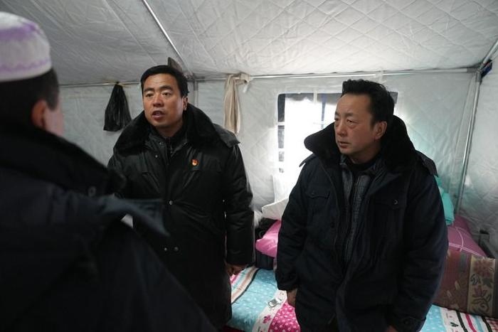 2023年12月22日，積石山縣大河家鎮(zhèn)大河村黨支部書記馬成忠（右二）在帳篷里和受災(zāi)群眾交流。新華社記者 陳斌 攝