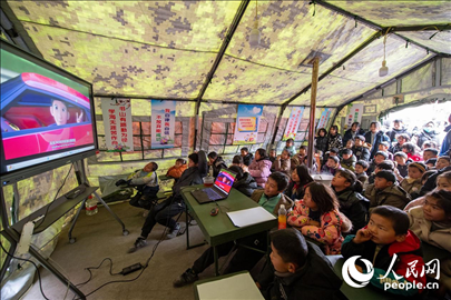 12月22日，在積石山縣大河家鎮(zhèn)大河村安置點(diǎn)，陸軍76集團(tuán)軍某旅搭建的“臨時學(xué)校”內(nèi)，小朋友正在看動畫片。人民網(wǎng)記者 翁奇羽攝