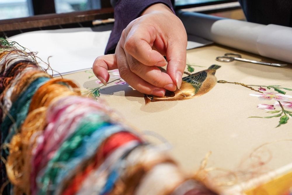 △2023年7月6日，盧建英在江蘇蘇州平江路的工作室內(nèi)刺繡。