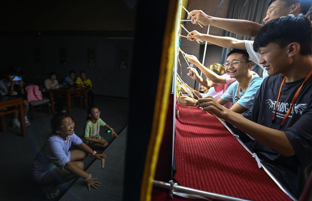 2023年8月8日，進(jìn)行暑期研學(xué)的學(xué)生在位于陜西省西安市的中國(guó)秦腔藝術(shù)博物館體驗(yàn)皮影戲演出。新華社記者 鄒競(jìng)一 攝