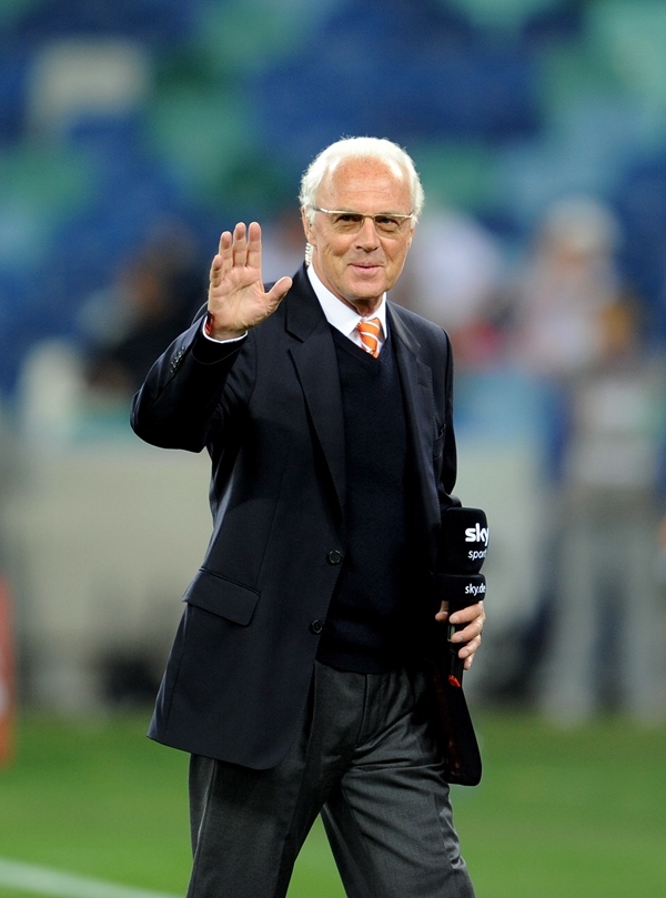 這是2010年7月7日，在南非德班舉行的2010年足球世界杯德國隊對陣西班牙隊的半決賽前，貝肯鮑爾接受電視臺采訪時和友人打招呼。新華社記者 王毓國 攝