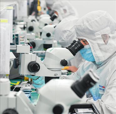 在位于武漢中國光谷的光電器件研發(fā)制造商——武漢光迅科技股份有限公司生產(chǎn)車間內(nèi)，技術(shù)人員在光模塊生產(chǎn)線作業(yè)（2023年4月11日攝）。程敏攝/本刊