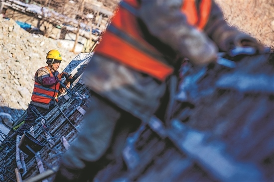 1月3日，房山區(qū)，工人正在雙泉河修筑堤壩。