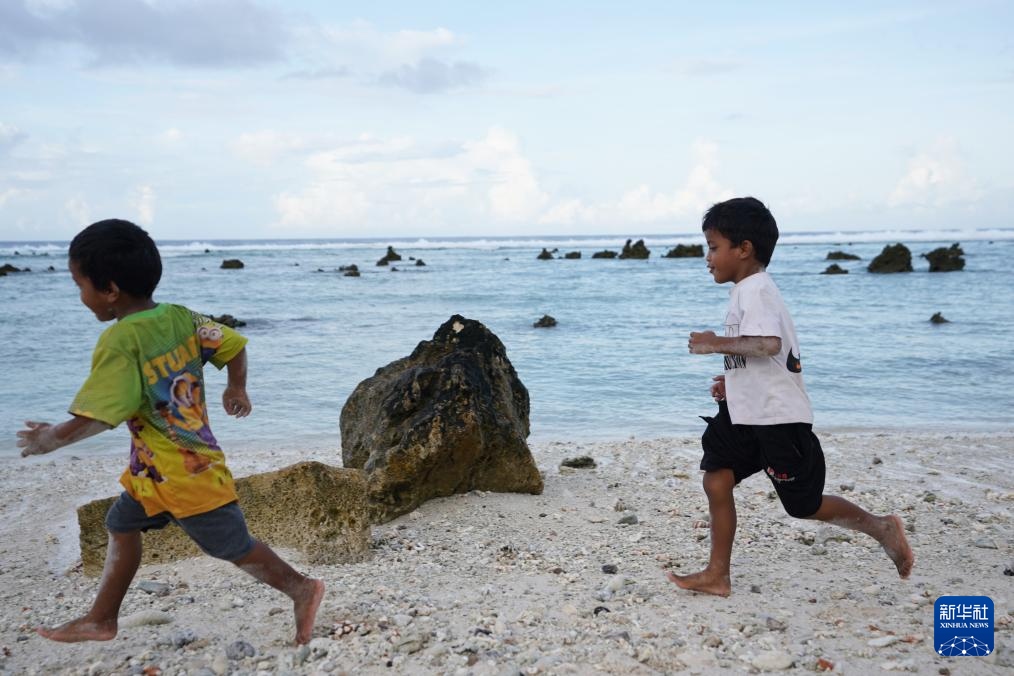 1月20日，兒童在瑙魯海邊嬉戲。新華社記者 王申 攝