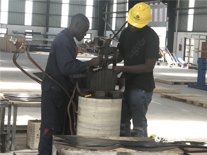 經(jīng)貿(mào)合作區(qū)廠房內(nèi)，當?shù)毓と苏诰o張作業(yè)。人民網(wǎng)記者 黃培昭攝