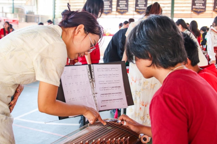 志愿者教師指導(dǎo)學(xué)生彈奏古箏?；顒?dòng)主辦方供圖