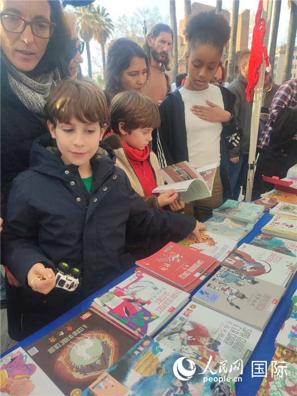 印刷精美的中國傳統(tǒng)文化叢書吸引了小游客的注意。人民網(wǎng)記者鄭彬攝