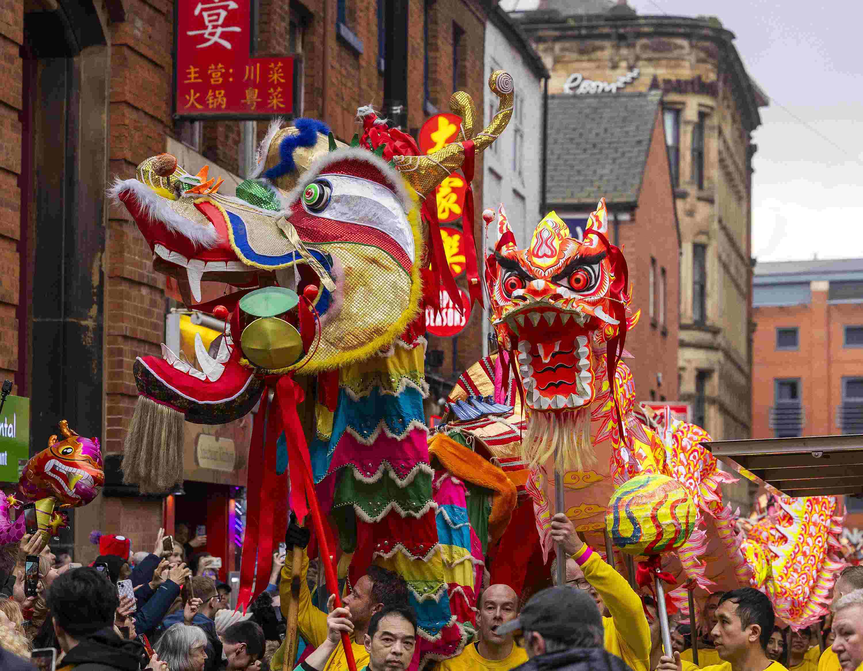 △ 當?shù)貢r間2024年2月11日，英國曼徹斯特，表演者進入中國城，參加中國農(nóng)歷龍年春節(jié)的慶?；顒?。