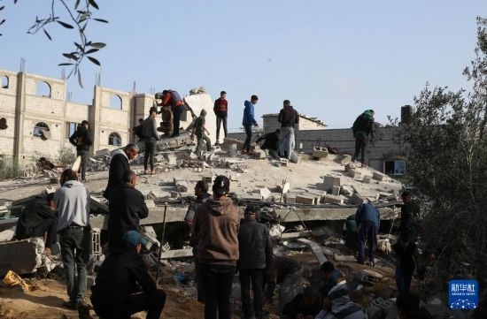  3月3日，在加沙地帶南部城市拉法，人們查看被以軍空襲破壞的建筑。新華社發(fā)（哈立德·奧馬爾攝）