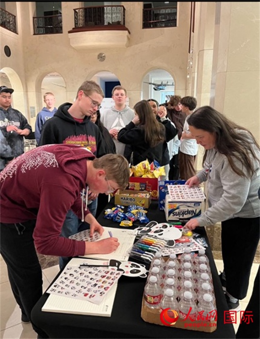 學(xué)生們出發(fā)前紛紛在留言簿留言。人民網(wǎng)記者 鄧圩攝