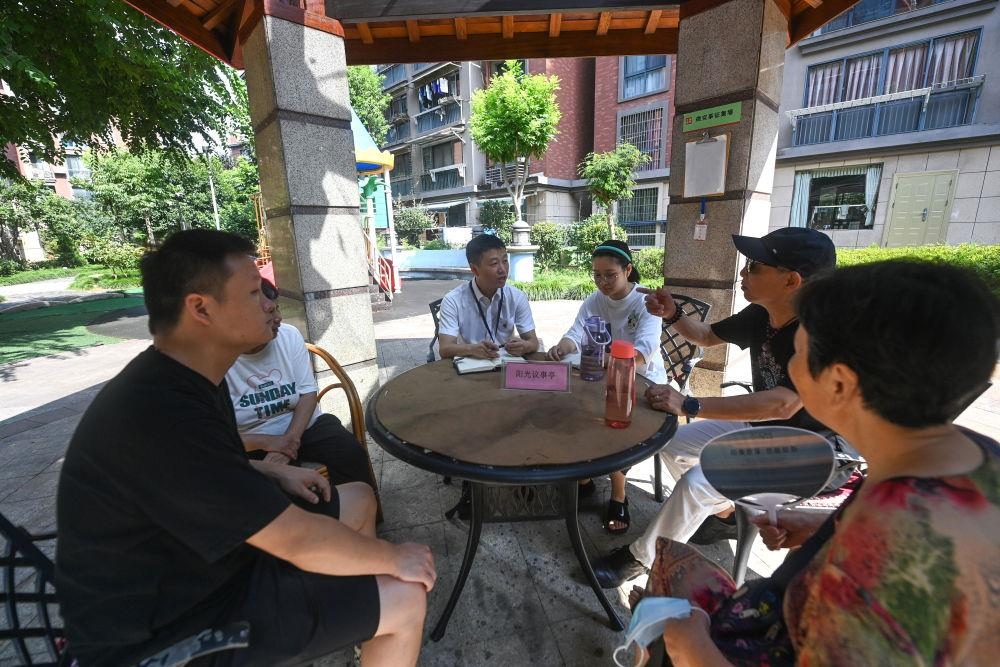 △2023年7月21日，在位于浙江杭州臨安區(qū)錦南街道水岸陽光小區(qū)的陽光議事廳，街道干部在聽取居民們反映的問題及意見。