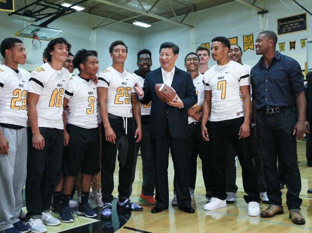 2015年9月23日，國(guó)家主席習(xí)近平參觀美國(guó)塔科馬市林肯中學(xué)。這是習(xí)近平在學(xué)校體育館，同上橄欖球訓(xùn)練課的學(xué)生們親切交談。新華社記者 蘭紅光 攝