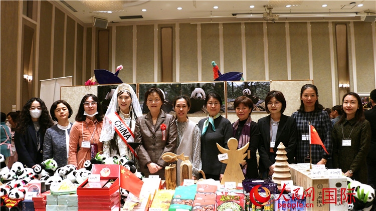 中國駐日本大使吳江浩夫人丁玥（左五）與使館人員在展位前合影留念。人民網(wǎng) 許可攝