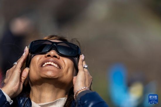 4月8日，一名女子在美國(guó)紐約州普拉茨堡觀看日食。新華社發(fā)（文森特·約翰遜攝）