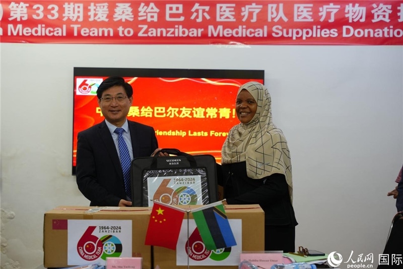江蘇省蘇北人民醫(yī)院黨委書(shū)記束余聲捐贈(zèng)物資與桑衛(wèi)生部首席秘書(shū)哈比巴。中國(guó)援桑醫(yī)療隊(duì)供圖