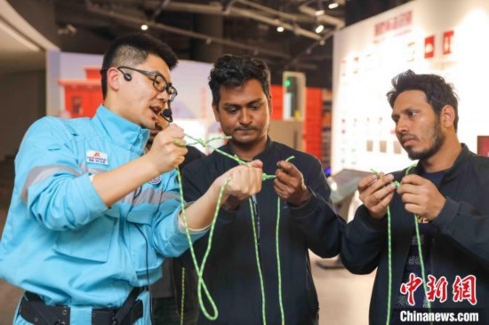 5月9日，工作人員指導(dǎo)留學(xué)生學(xué)習(xí)打繩結(jié)。張鷹 攝