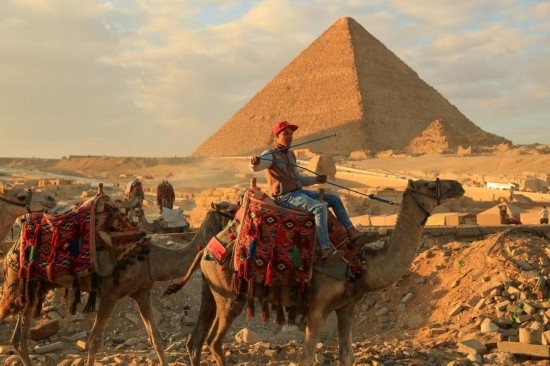 1月24日，商販騎駱駝離開埃及吉薩金字塔景區(qū)。新華社記者 隋先凱 攝