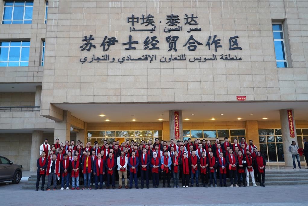 2024年2月11日，在位于埃及蘇伊士省的中?！ぬ┻_蘇伊士經(jīng)貿(mào)合作區(qū)，中埃員工在合作區(qū)辦公大樓前合影拜年。新華社發(fā)（泰達合作區(qū)供圖）