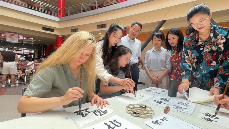 羅馬尼亞友人在活動(dòng)現(xiàn)場(chǎng)學(xué)寫漢字。中國(guó)駐羅馬尼亞大使館領(lǐng)僑處供圖