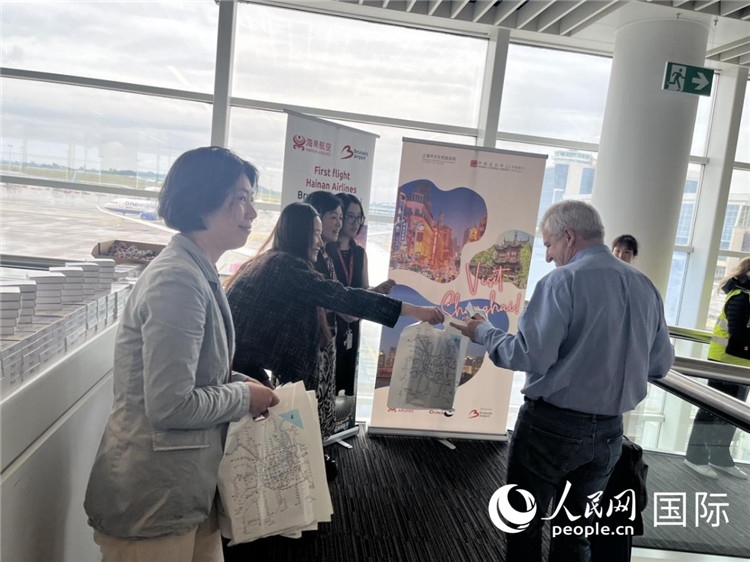 圖為工作人員向乘客發(fā)放復(fù)航首班禮物。 牛瑞飛攝