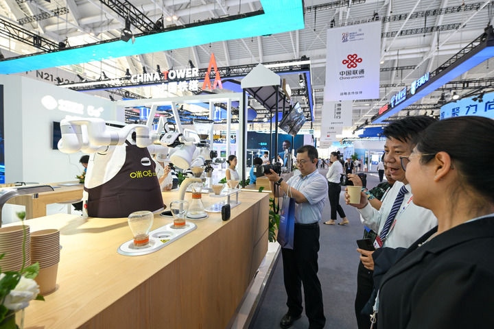 6月20日，與會者品嘗機(jī)器人沖調(diào)出的咖啡。新華社記者 孫凡越 攝