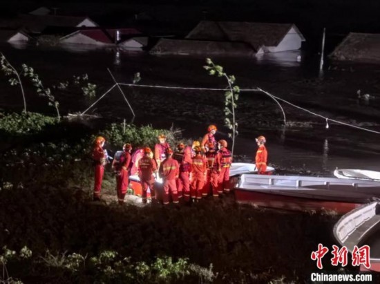  7月6日凌晨3時(shí)，在湖南岳陽華容縣團(tuán)洲垸洞庭湖一線堤防，救援人員剛剛完成一次救援任務(wù)，遠(yuǎn)處是被淹的民房。中新社記者 白祖偕 攝